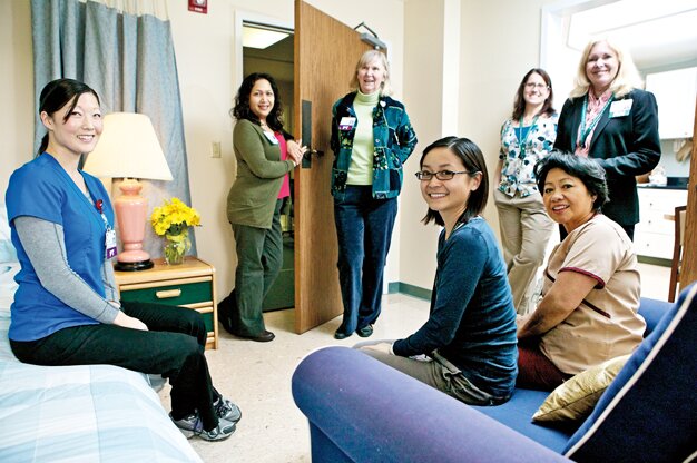 The staff at the Mission Oaks campus of Good Samaritan Hospital gathers in the simulated apartment where stroke patients work on their daily living skills. 