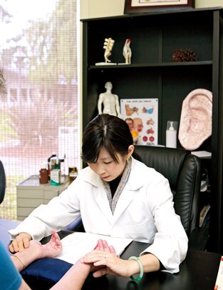 In her Sunnyvale office, Dr. Ching Ching Chi treats a stroke patient with acupuncture. 